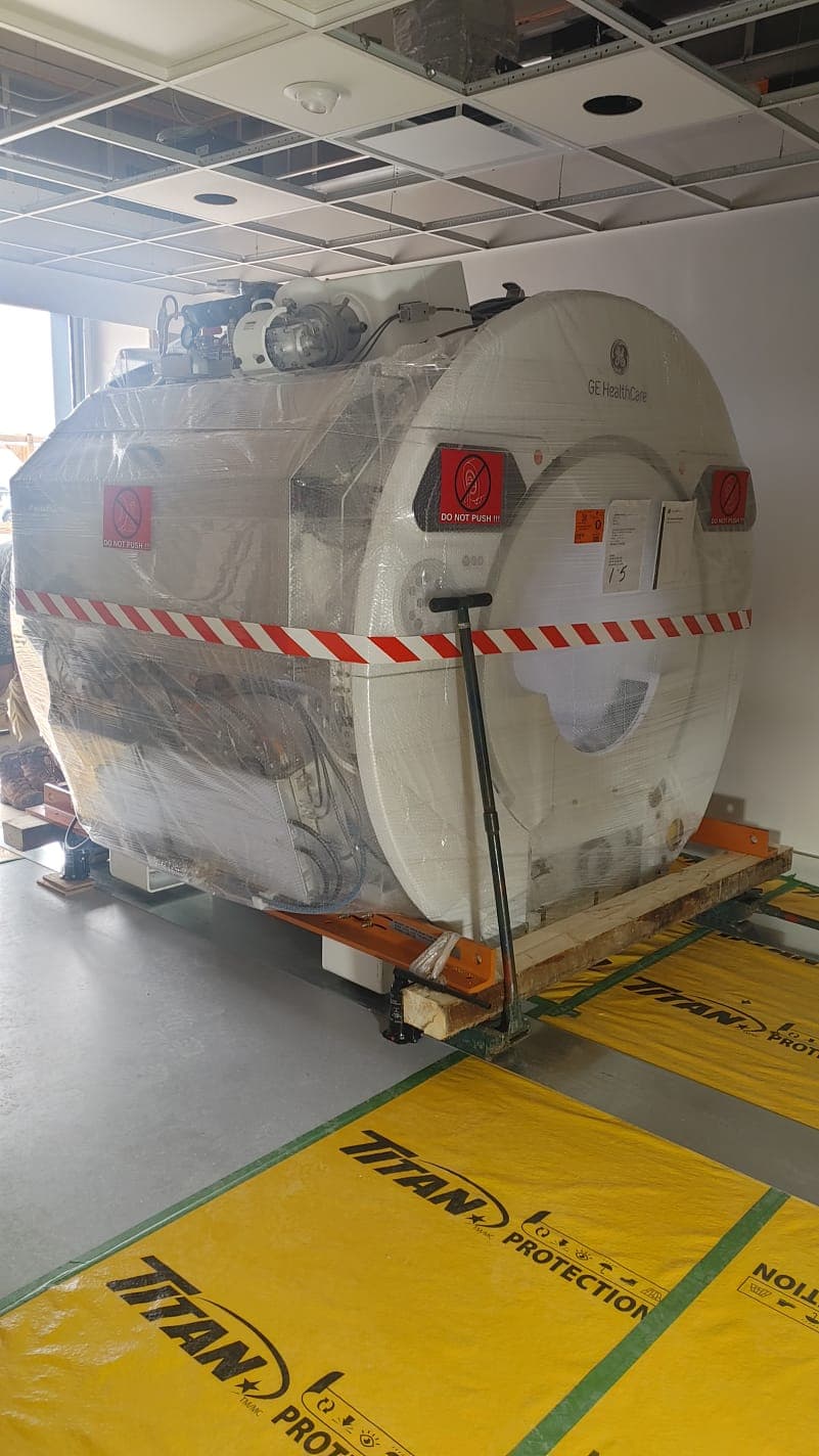 GE HealthCare 1.5T MRI wrapped and positioned inside the scan room