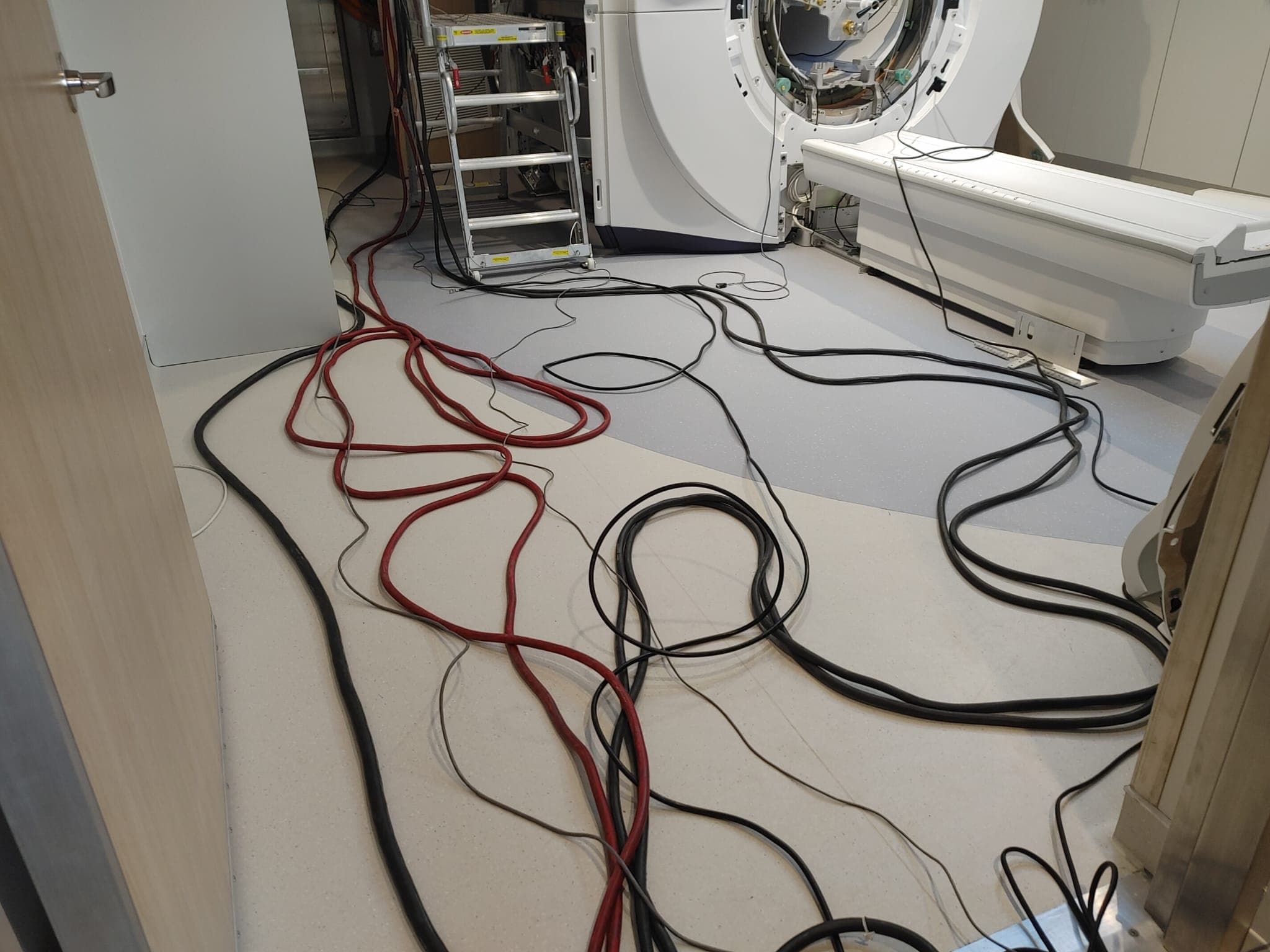 Power and signal cabling run between the MRI scanner and its equipment cabinets